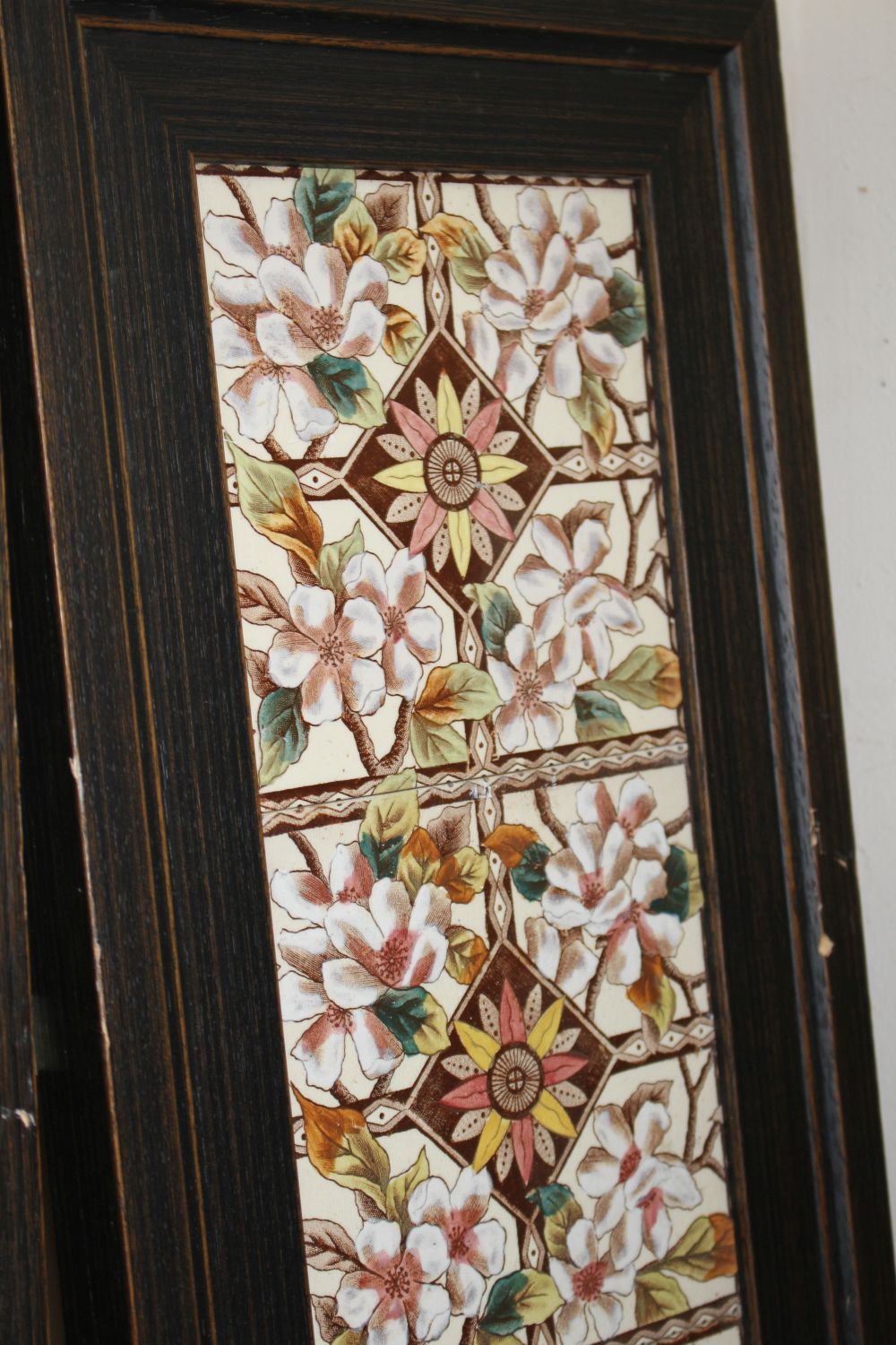 A pair of Victorian apple blossom tile panels and a set of six Art Nouveau foliate design tiles, all framed